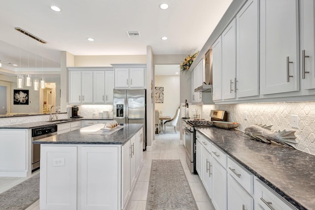 11051 SW Ivory Springs Ln, Port Saint Lucie, FL 34987 - kitchen with appliances with stainless steel finishes, decorative backsplash, a kitchen island, dark stone counters, and recessed lighting