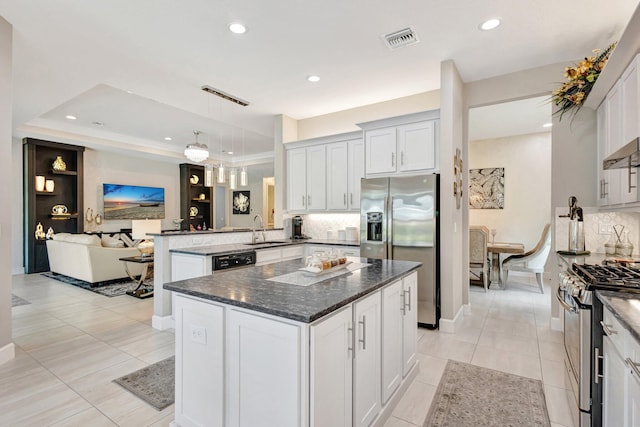 11051 SW Ivory Springs Ln, Port Saint Lucie, FL 34987 - kitchen with stainless steel appliances, a sink, a peninsula, decorative backsplash, and recessed lighting