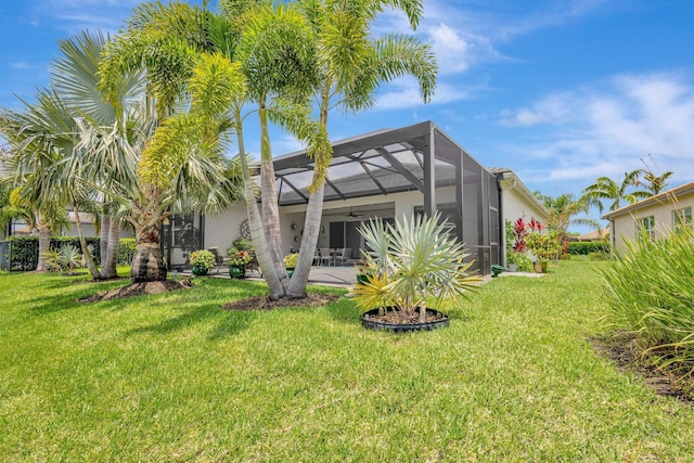 11051 SW Ivory Springs Ln, Port Saint Lucie, FL 34987 - back of property featuring a lawn, a patio, glass enclosure, and stucco siding
