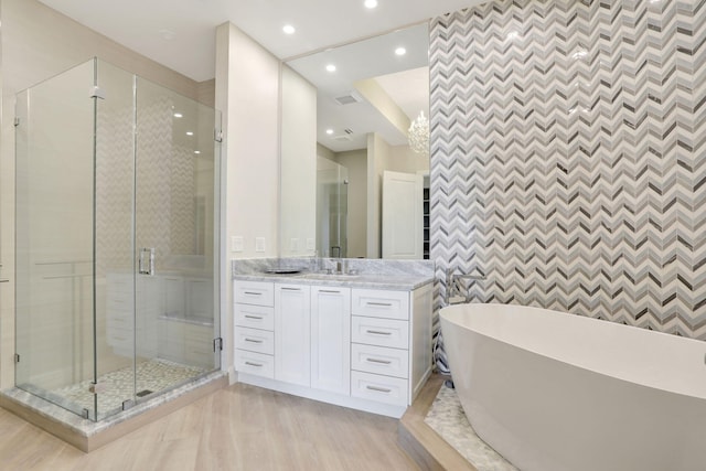 1 N Ocean Blvd Unit Ph05, Pompano Beach, FL 33062 - full bath featuring a soaking tub, vanity, a stall shower, wood finished floors, and an accent wall