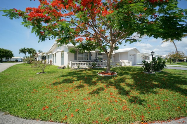 1902 SW 16th Ave, Boynton Beach, FL 33426 - view of front of house featuring a front lawn, stucco siding, a garage, and covered porch