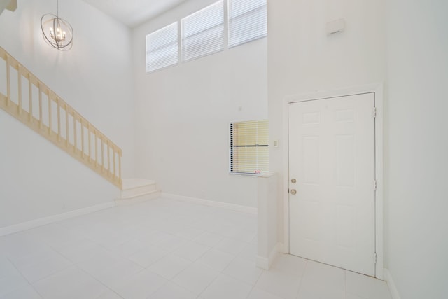 12236 Sag Harbor Ct Unit 3, Wellington, FL 33414 - entrance foyer with stairway, a towering ceiling, a chandelier, tile patterned flooring, and baseboards