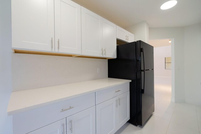 12236 Sag Harbor Ct Unit 3, Wellington, FL 33414 - kitchen featuring freestanding refrigerator, white cabinets, light countertops, light tile patterned floors, and baseboards