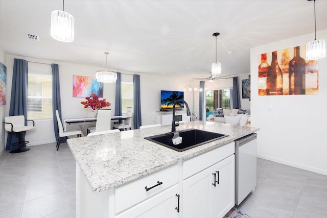 12314 SW Rimini Way, Port Saint Lucie, FL 34987 - kitchen featuring dishwasher, a sink, light tile patterned flooring, and light stone countertops