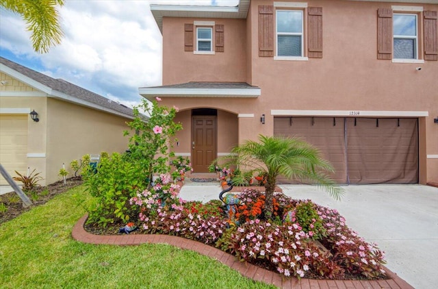 12314 SW Rimini Way, Port Saint Lucie, FL 34987 - view of front of home with stucco siding, a garage, and driveway