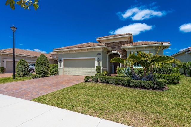 8762 SW Montova Way, Port Saint Lucie, FL 34987 - mediterranean / spanish-style house with stucco siding, decorative driveway, an attached garage, a front lawn, and a tiled roof