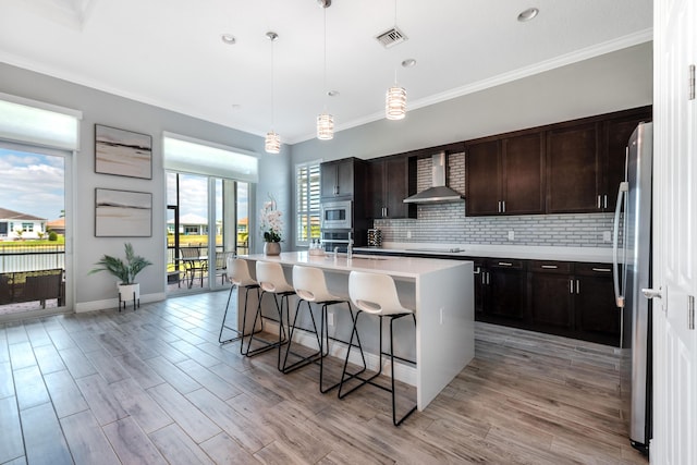 8762 SW Montova Way, Port Saint Lucie, FL 34987 - kitchen featuring wall chimney exhaust hood, appliances with stainless steel finishes, a breakfast bar, backsplash, and light countertops