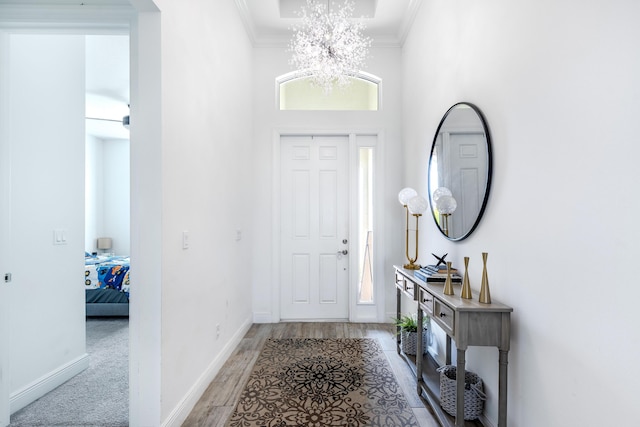 8762 SW Montova Way, Port Saint Lucie, FL 34987 - entrance foyer featuring crown molding, a chandelier, baseboards, and light wood finished floors