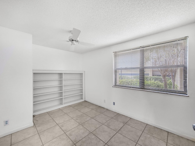3961 SW Greenwood Way Unit D, Palm City, FL 34990 - spare room with a textured ceiling, light tile patterned flooring, a ceiling fan, baseboards, and built in features