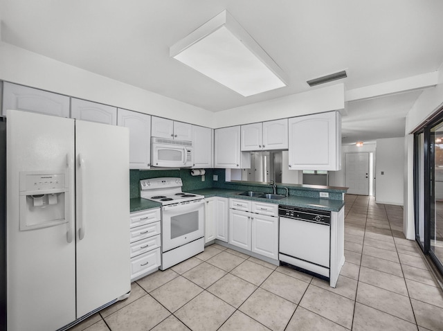3961 SW Greenwood Way Unit D, Palm City, FL 34990 - kitchen with white appliances, dark countertops, a sink, and white cabinets