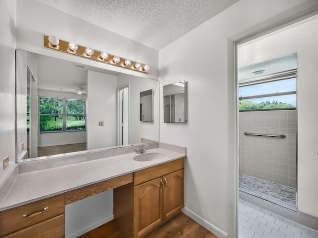 3961 SW Greenwood Way Unit D, Palm City, FL 34990 - full bath featuring plenty of natural light, tiled shower, vanity, a textured ceiling, and a ceiling fan