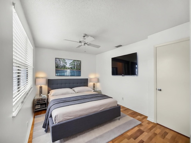 3961 SW Greenwood Way Unit D, Palm City, FL 34990 - bedroom featuring light wood-style flooring, baseboards, a ceiling fan, and a textured ceiling