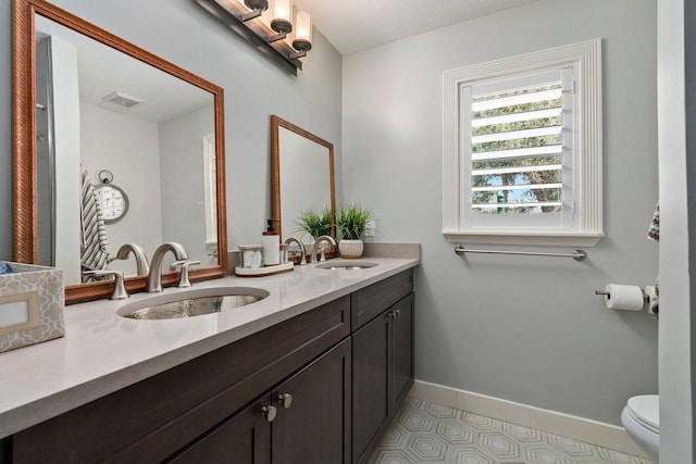 16673 75th Way N, Palm Beach Gardens, FL 33418 - bathroom with double vanity, toilet, and baseboards