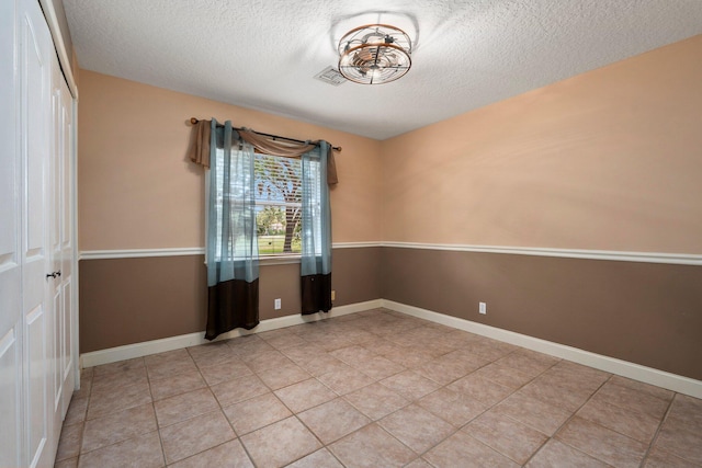 16673 75th Way N, Palm Beach Gardens, FL 33418 - spare room featuring a textured ceiling, light tile patterned floors, and baseboards