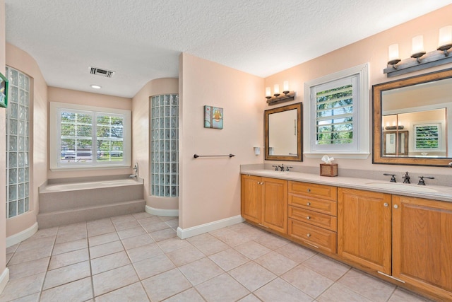 16673 75th Way N, Palm Beach Gardens, FL 33418 - bathroom featuring double vanity, a bath, baseboards, tile patterned floors, and a textured ceiling