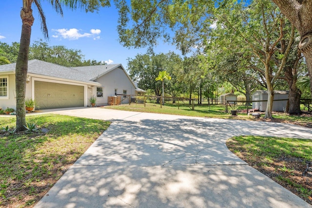 16673 75th Way N, Palm Beach Gardens, FL 33418 - view of front of house featuring driveway, an attached garage, stucco siding, and roof with shingles