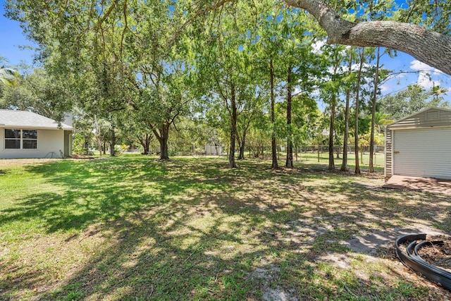 16673 75th Way N, Palm Beach Gardens, FL 33418 - view of grassy yard featuring an outbuilding