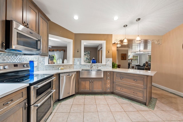 16673 75th Way N, Palm Beach Gardens, FL 33418 - kitchen with stainless steel appliances, a sink, tasteful backsplash, light countertops, and hanging light fixtures