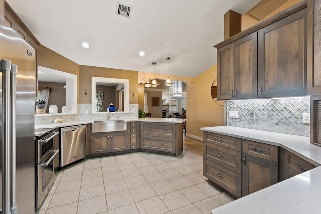 16673 75th Way N, Palm Beach Gardens, FL 33418 - kitchen featuring appliances with stainless steel finishes, a sink, decorative backsplash, light tile patterned flooring, and light countertops