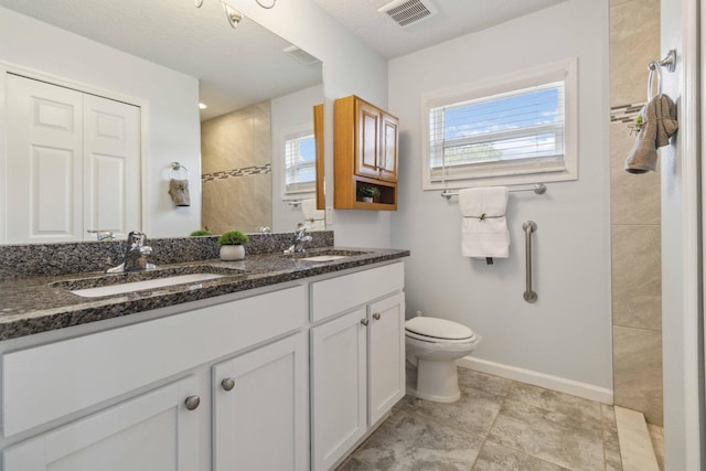 1649 Talbott St SE, Palm Bay, FL 32909 - bathroom featuring double vanity, toilet, tiled shower, and baseboards