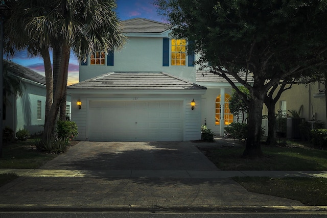 123 Canterbury Pl, Royal Palm Beach, FL 33414 - view of front facade featuring decorative driveway, a tiled roof, an attached garage, and stucco siding