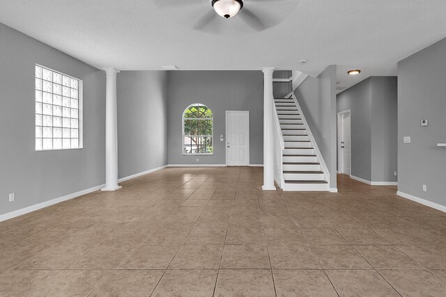 123 Canterbury Pl, Royal Palm Beach, FL 33414 - foyer with ornate columns, a ceiling fan, stairway, light tile patterned flooring, and a textured ceiling