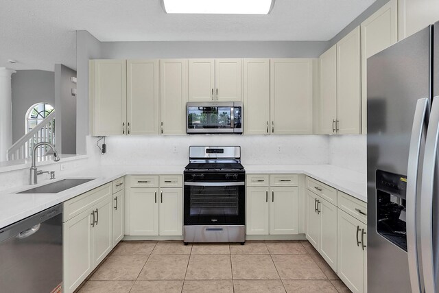 123 Canterbury Pl, Royal Palm Beach, FL 33414 - kitchen with stainless steel appliances, a sink, light countertops, and light tile patterned flooring