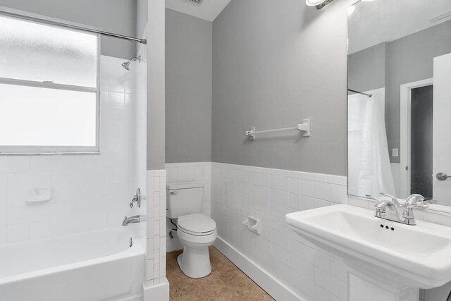 123 Canterbury Pl, Royal Palm Beach, FL 33414 - bathroom with toilet, a sink, shower / bath combination with curtain, tile walls, and a wainscoted wall