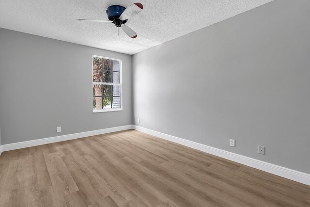 123 Canterbury Pl, Royal Palm Beach, FL 33414 - spare room featuring a textured ceiling, a ceiling fan, wood finished floors, and baseboards