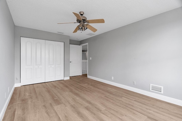 123 Canterbury Pl, Royal Palm Beach, FL 33414 - unfurnished bedroom with light wood finished floors, baseboards, and a textured ceiling