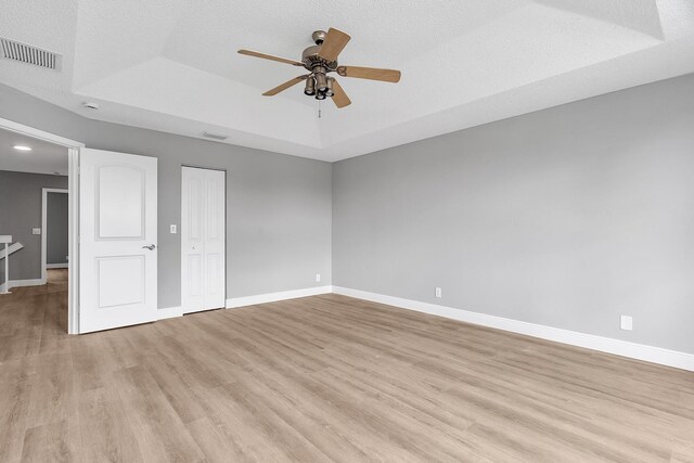 123 Canterbury Pl, Royal Palm Beach, FL 33414 - unfurnished bedroom featuring a raised ceiling, light wood-type flooring, baseboards, and ceiling fan