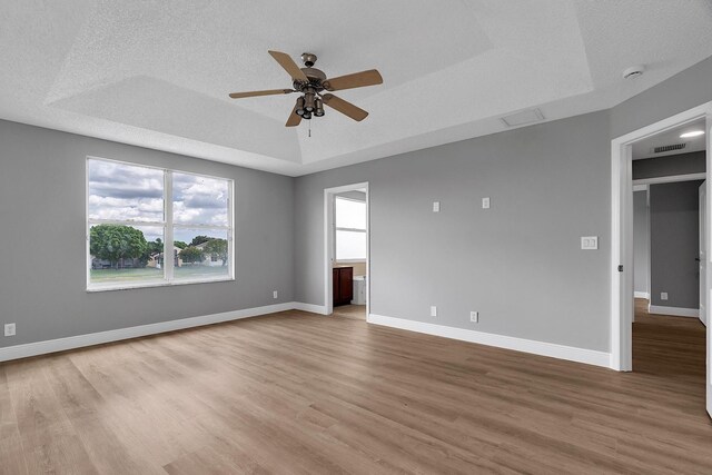 123 Canterbury Pl, Royal Palm Beach, FL 33414 - empty room with a raised ceiling, wood finished floors, ceiling fan, baseboards, and a textured ceiling