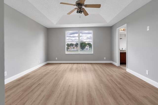 123 Canterbury Pl, Royal Palm Beach, FL 33414 - spare room featuring a raised ceiling, light wood-style flooring, ceiling fan, a textured ceiling, and baseboards
