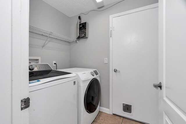 123 Canterbury Pl, Royal Palm Beach, FL 33414 - washroom with washer and clothes dryer, light tile patterned floors, and a textured ceiling