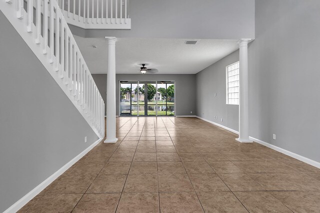 123 Canterbury Pl, Royal Palm Beach, FL 33414 - unfurnished living room featuring ceiling fan, ornate columns, stairs, and baseboards