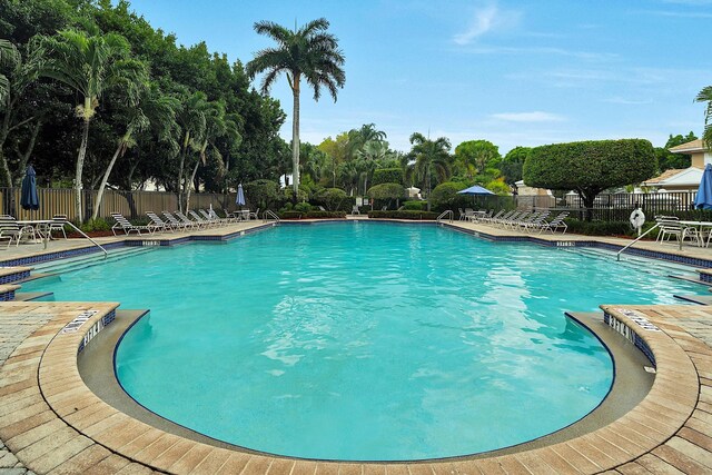 123 Canterbury Pl, Royal Palm Beach, FL 33414 - community pool featuring a patio and view of scattered trees