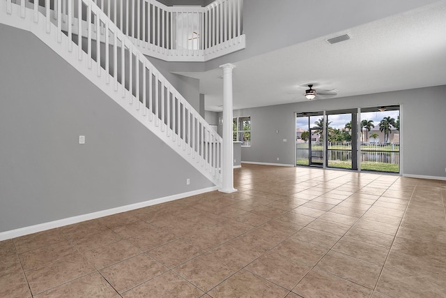 123 Canterbury Pl, Royal Palm Beach, FL 33414 - unfurnished living room with ceiling fan, baseboards, tile patterned flooring, ornate columns, and stairs