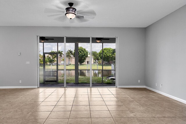 123 Canterbury Pl, Royal Palm Beach, FL 33414 - unfurnished room with ceiling fan, a water view, tile patterned flooring, and baseboards