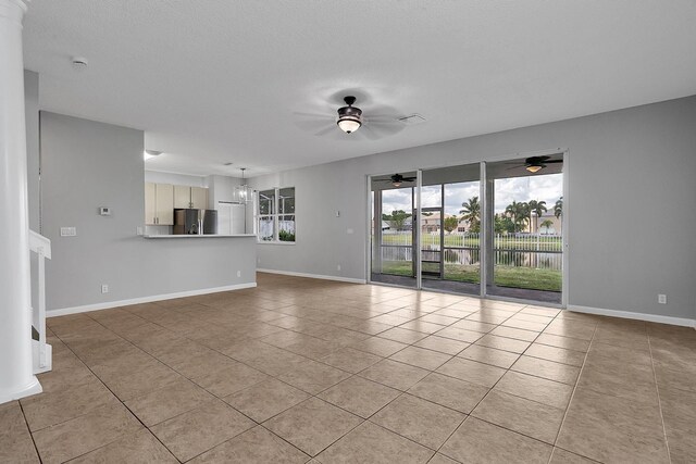 123 Canterbury Pl, Royal Palm Beach, FL 33414 - unfurnished living room with a ceiling fan, light tile patterned floors, baseboards, and a chandelier