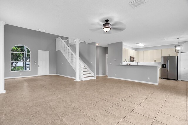 123 Canterbury Pl, Royal Palm Beach, FL 33414 - unfurnished living room featuring ceiling fan, light tile patterned flooring, baseboards, stairway, and a chandelier