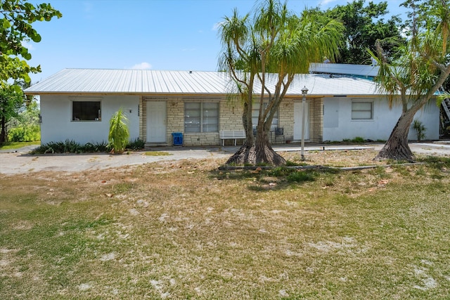 11331 SE Gold Ave, Hobe Sound, FL 33455 - single story home featuring stucco siding, a front yard, metal roof, and stone siding