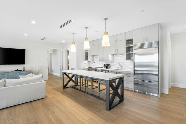 526 N Ocean Blvd, Delray Beach, FL 33483 - kitchen with built in refrigerator, open shelves, baseboards, a sink, and tasteful backsplash