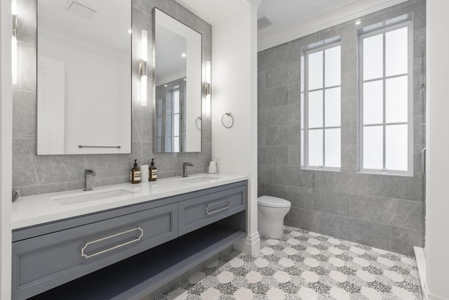 526 N Ocean Blvd, Delray Beach, FL 33483 - bathroom featuring tile walls, ornamental molding, double vanity, toilet, and plenty of natural light