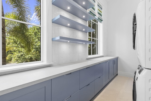 526 N Ocean Blvd, Delray Beach, FL 33483 - kitchen with stacked washing machine and dryer, open shelves, tasteful backsplash, and healthy amount of natural light