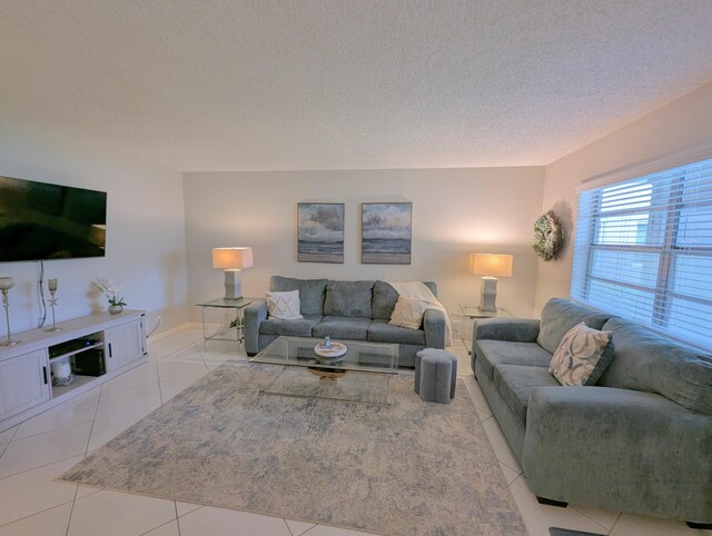 349 Piedmont H, Delray Beach, FL 33484 - living area with a textured ceiling, light tile patterned floors, and baseboards