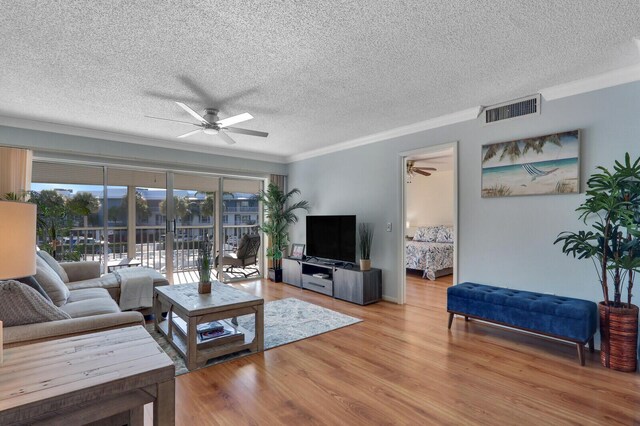 1858 SW Palm City Rd Unit 205, Stuart, FL 34994 - living room with a ceiling fan, ornamental molding, a textured ceiling, and wood finished floors