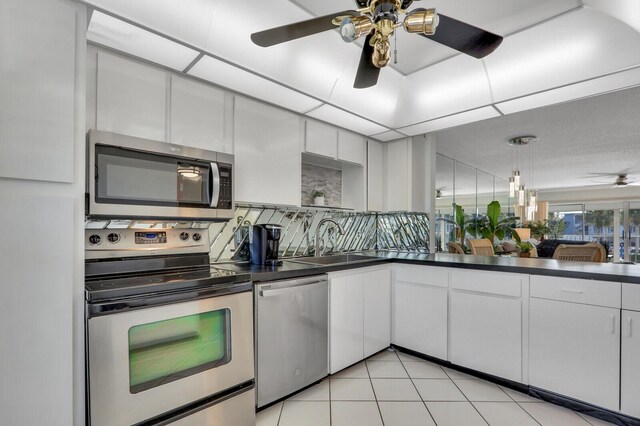 1858 SW Palm City Rd Unit 205, Stuart, FL 34994 - kitchen featuring stainless steel appliances, dark countertops, ceiling fan, a sink, and white cabinets