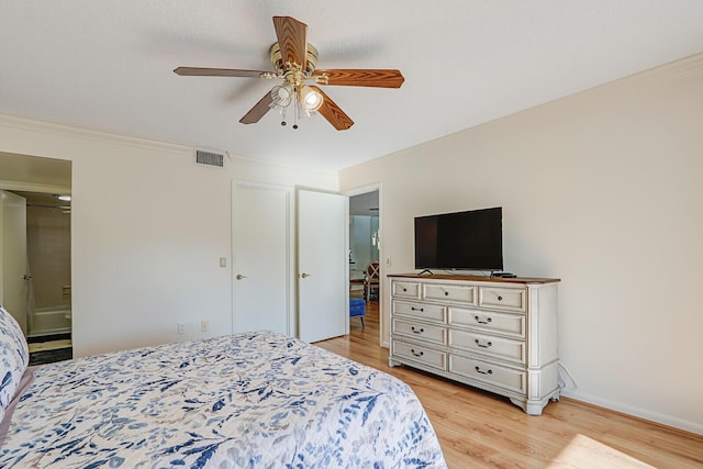 1858 SW Palm City Rd Unit 205, Stuart, FL 34994 - bedroom with light wood finished floors, a ceiling fan, connected bathroom, and crown molding