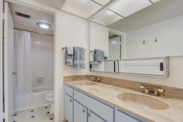 1858 SW Palm City Rd Unit 205, Stuart, FL 34994 - bathroom featuring toilet, double vanity, shower / bath combo with shower curtain, and tile patterned flooring