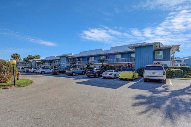 1858 SW Palm City Rd Unit 205, Stuart, FL 34994 - view of building exterior featuring uncovered parking and a residential view